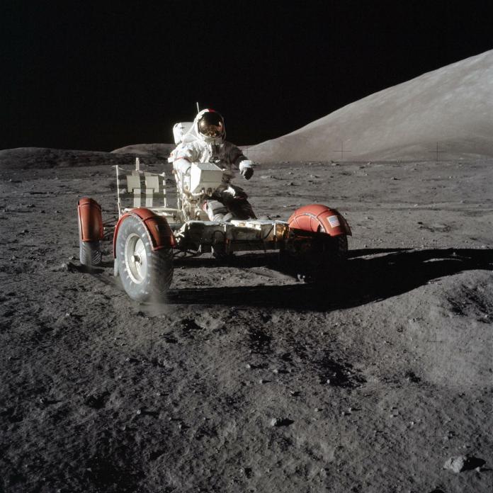 Astronaut Eugene Cernan sits on a barebones Lunar Roving Vehicle during Apollo 17 in 1972. After lowering it from the Lunar Module and unfolding it, astronauts had to raise the seats and install equipment like communications antennae. In this image, the astronauts have not finishing loading equipment onto the LRV.