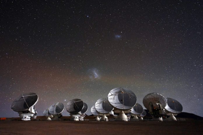 Dish-type antennas staring at a star-strewn sky.