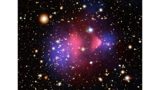 In space, an endless smattering of bright points with a faint cloud of purple and pink gases in the center.