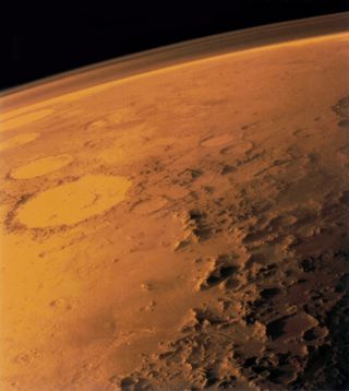 An image from space of part of mars, its thin atmosphere laced over top..