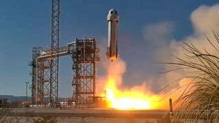 a white-and-blue rocket launches under a blue sky