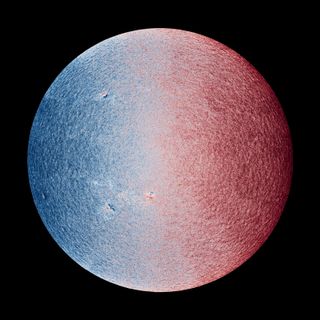 a grainy circle that fades left to right from blue to white to red.