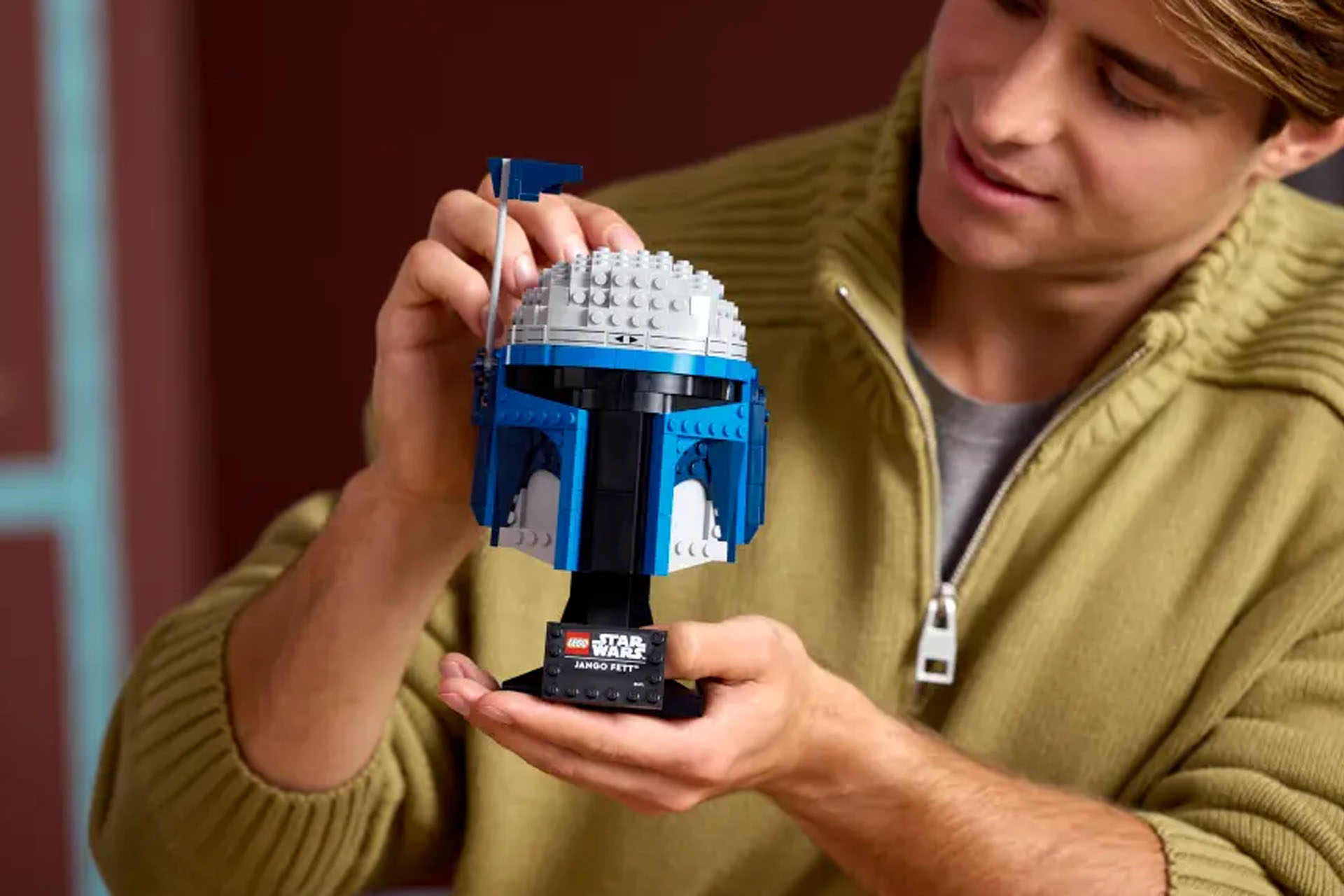 A Lego Star Wars Jango Fett Helmet being held in a person's hands.