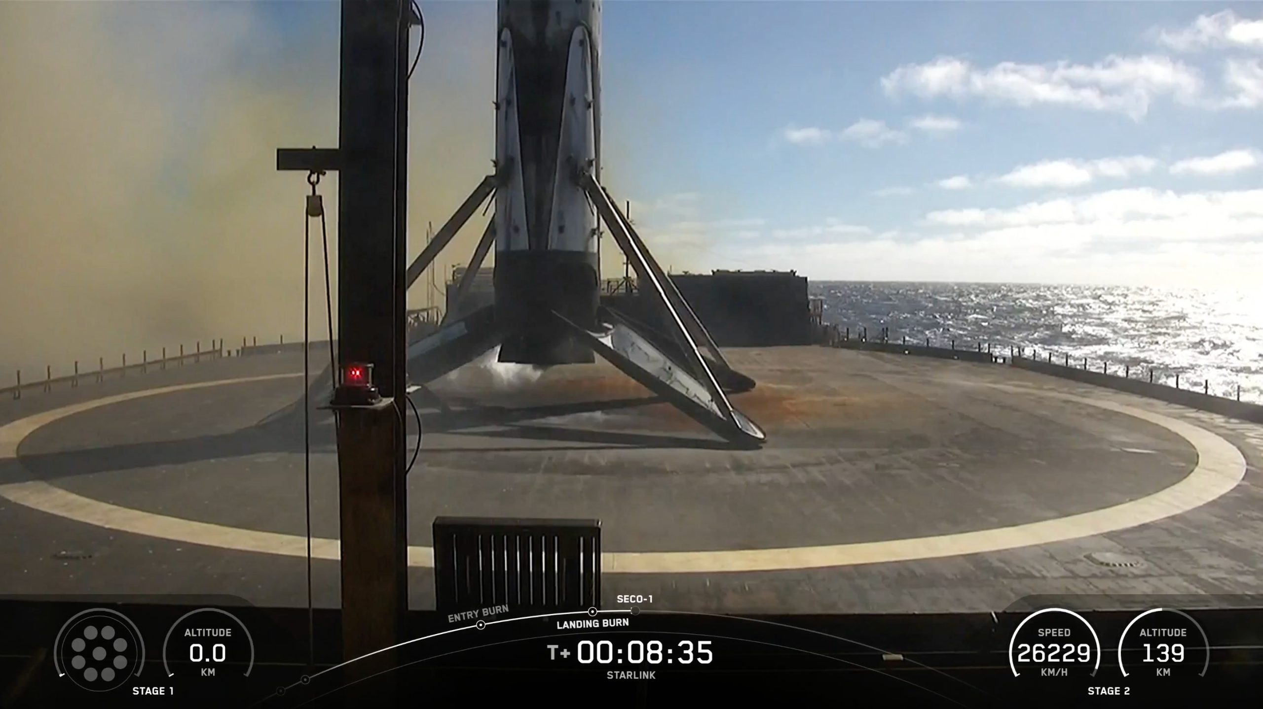 a black and white rocket rests on the deck of a ship at sea on a sunny day