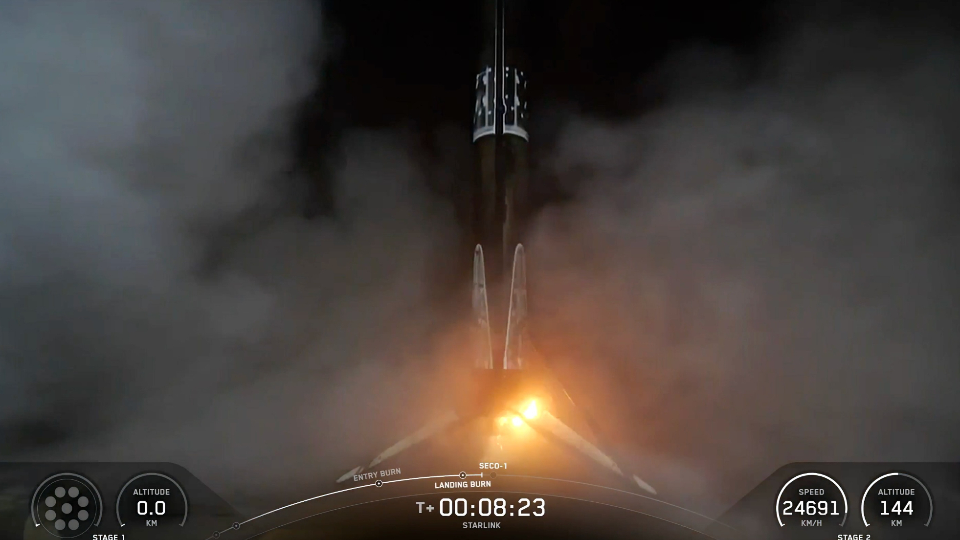 A black and white spacex falcon 9 rocket first stage sits on the deck of a ship at sea.