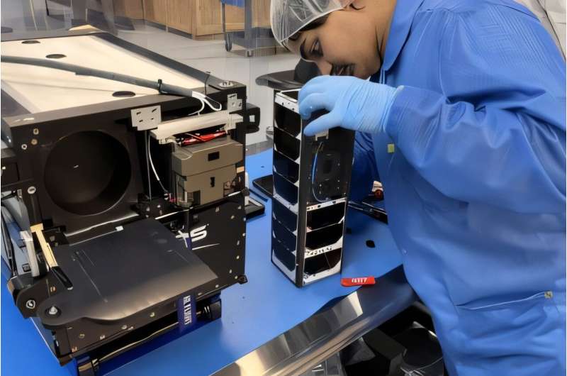 Sanjeev Mehta, a UNH research project engineer for the 3UCubed mission, inspects the Cubesat. Credit: UNH Student-built satellite will blast into space, collects data for NASA's IMAP mission