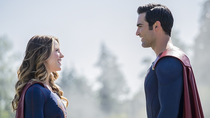 Still from the Supergirl TV series. Supergirl and Superman smiling at each other.