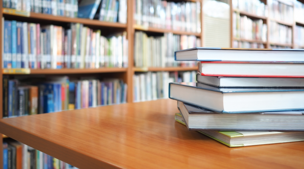 Library books stacked on a table.