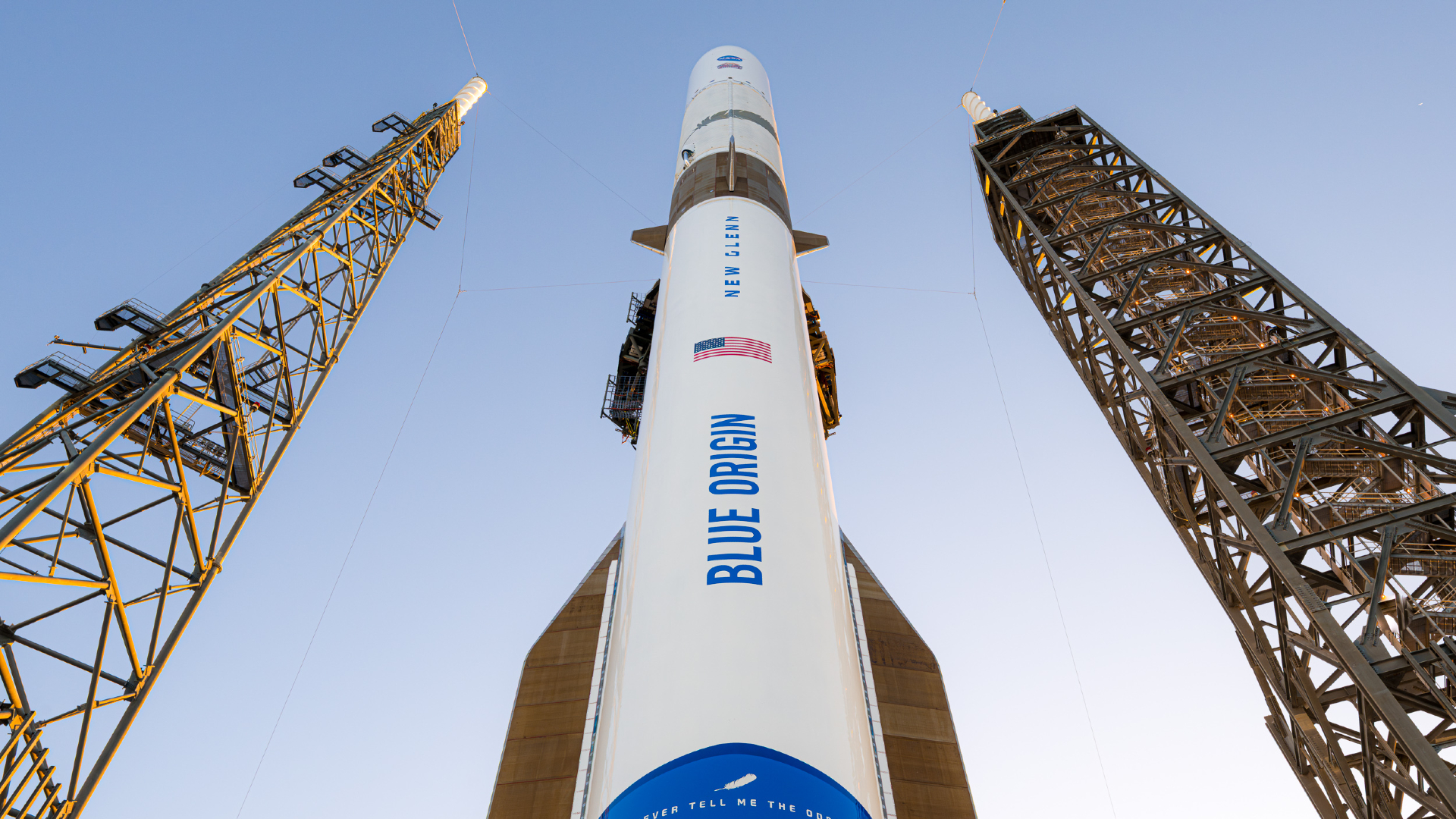 A white and blue Blue Origin rocket stands atop its launch pad for a NASA Mars launch.