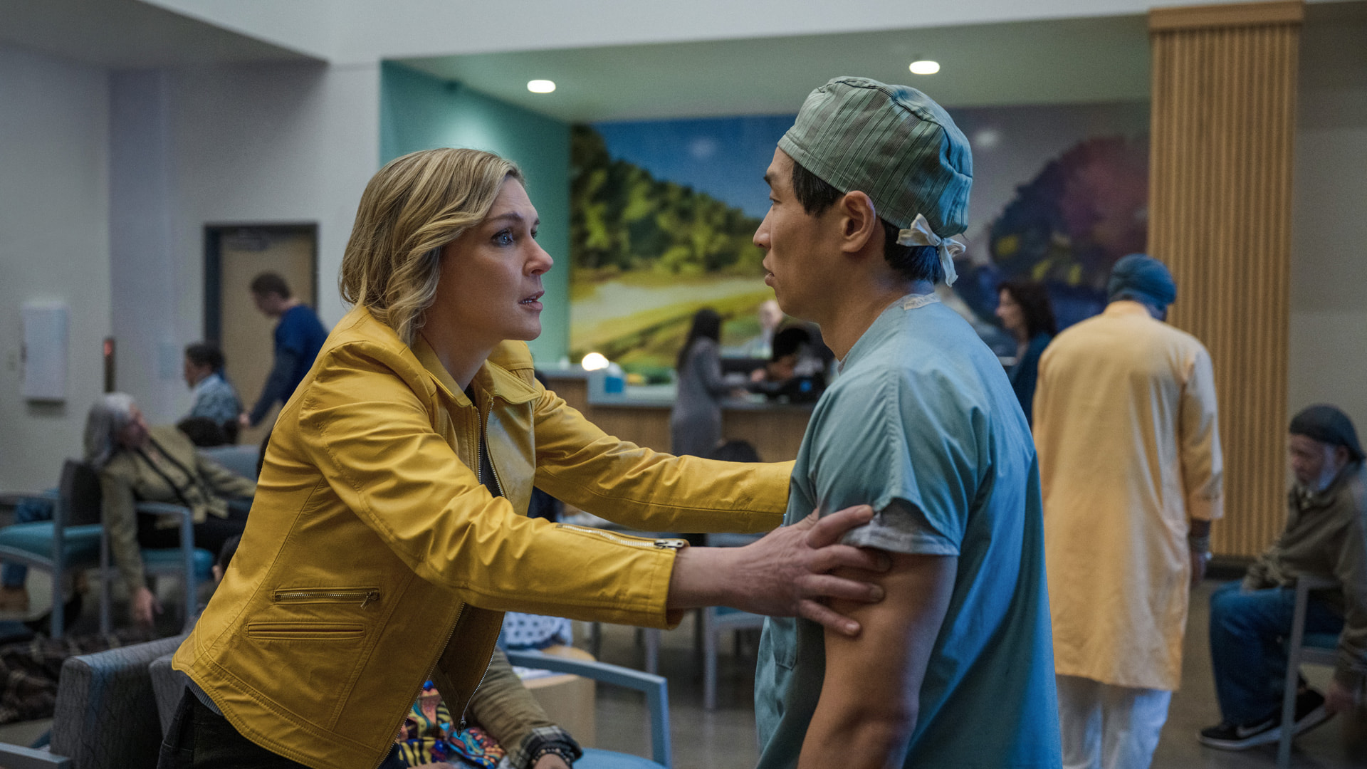 a woman in a yellow coast confronts a doctor in a hospital
