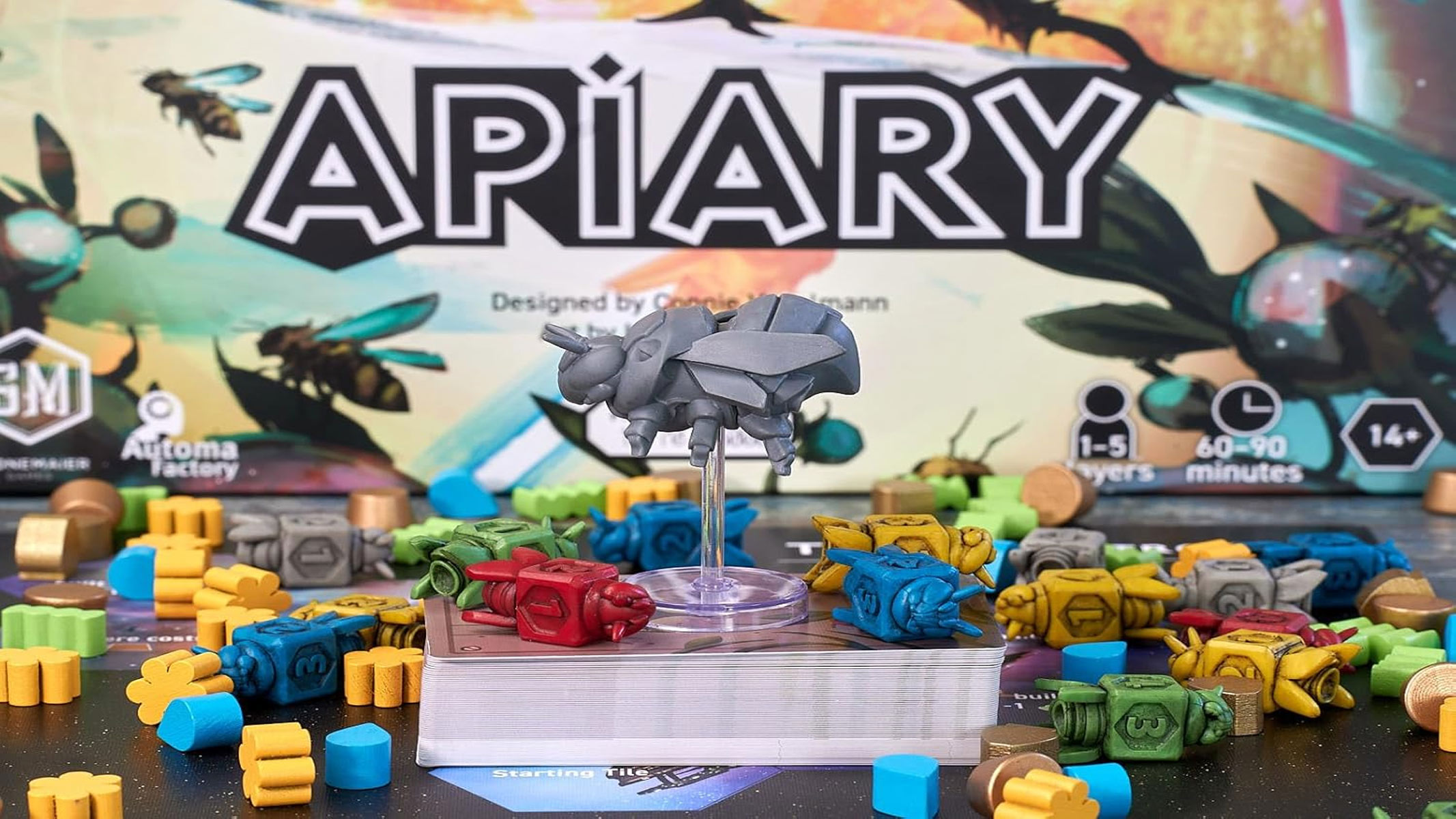 A grey bee game piece is towering over several countless colored game pieces in front of the Apiary logo.