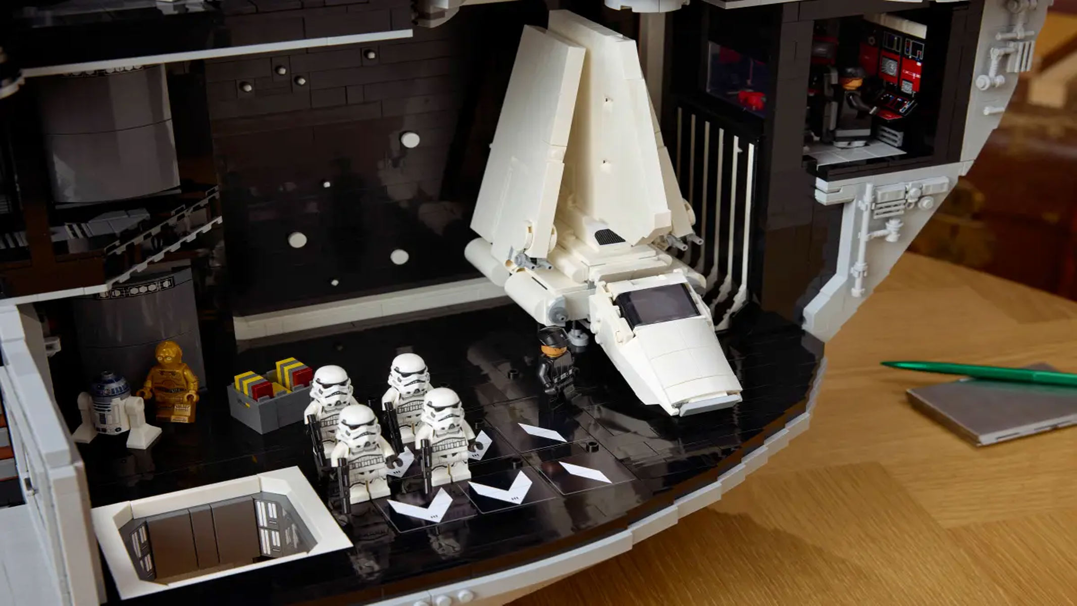 The interior of a circular space station with several floors and rooms filled with minifigures shows the minifigures posed in action.