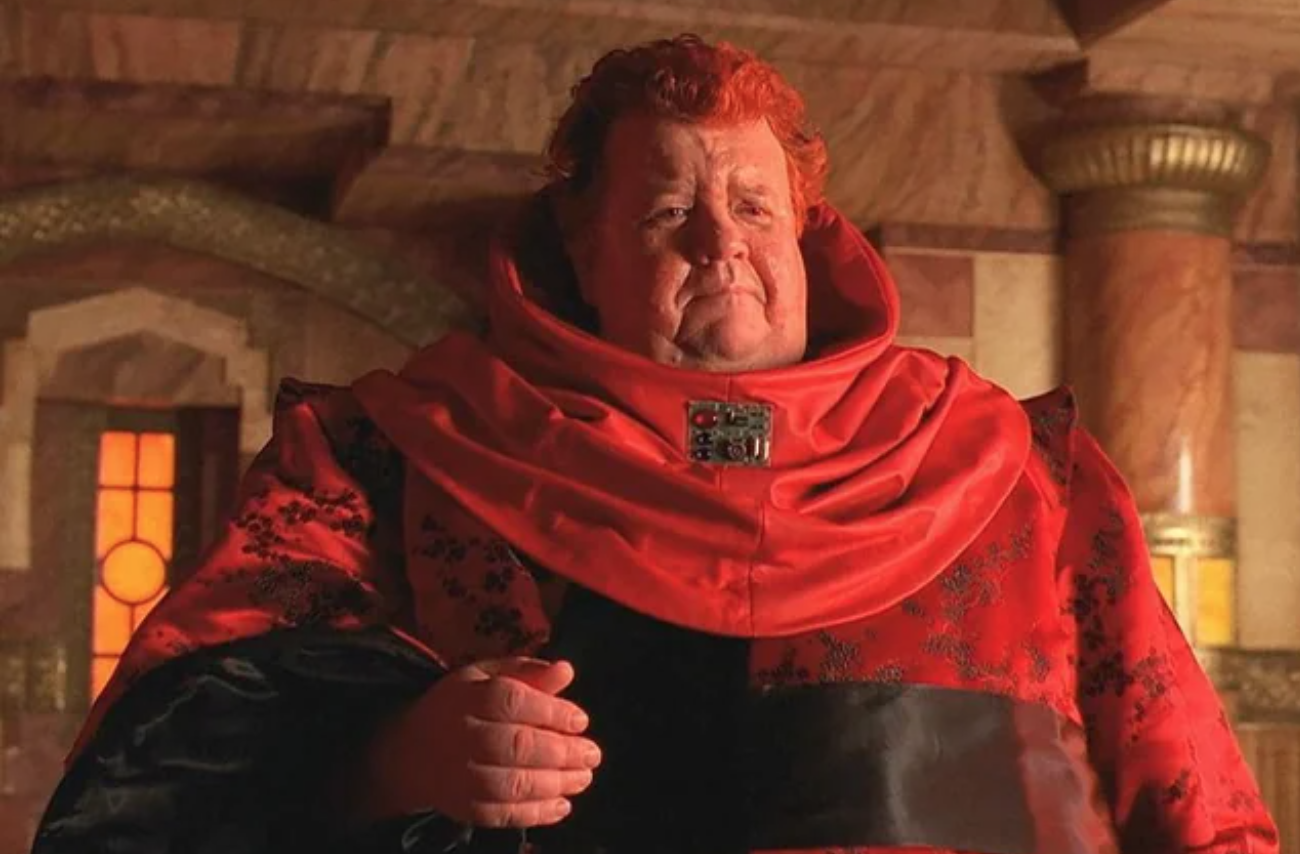 a large red-haired man in an elaborate red robe