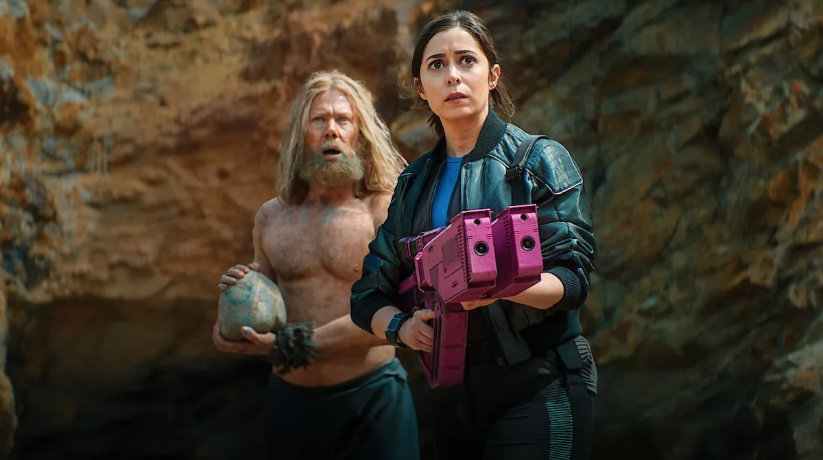 a sci-fi woman with a huge weapon and a bare-chested feral man