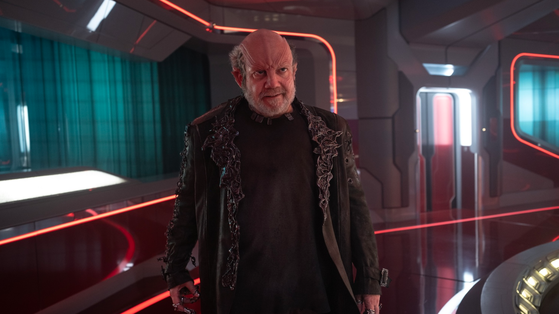 an alien man on a starship bridge