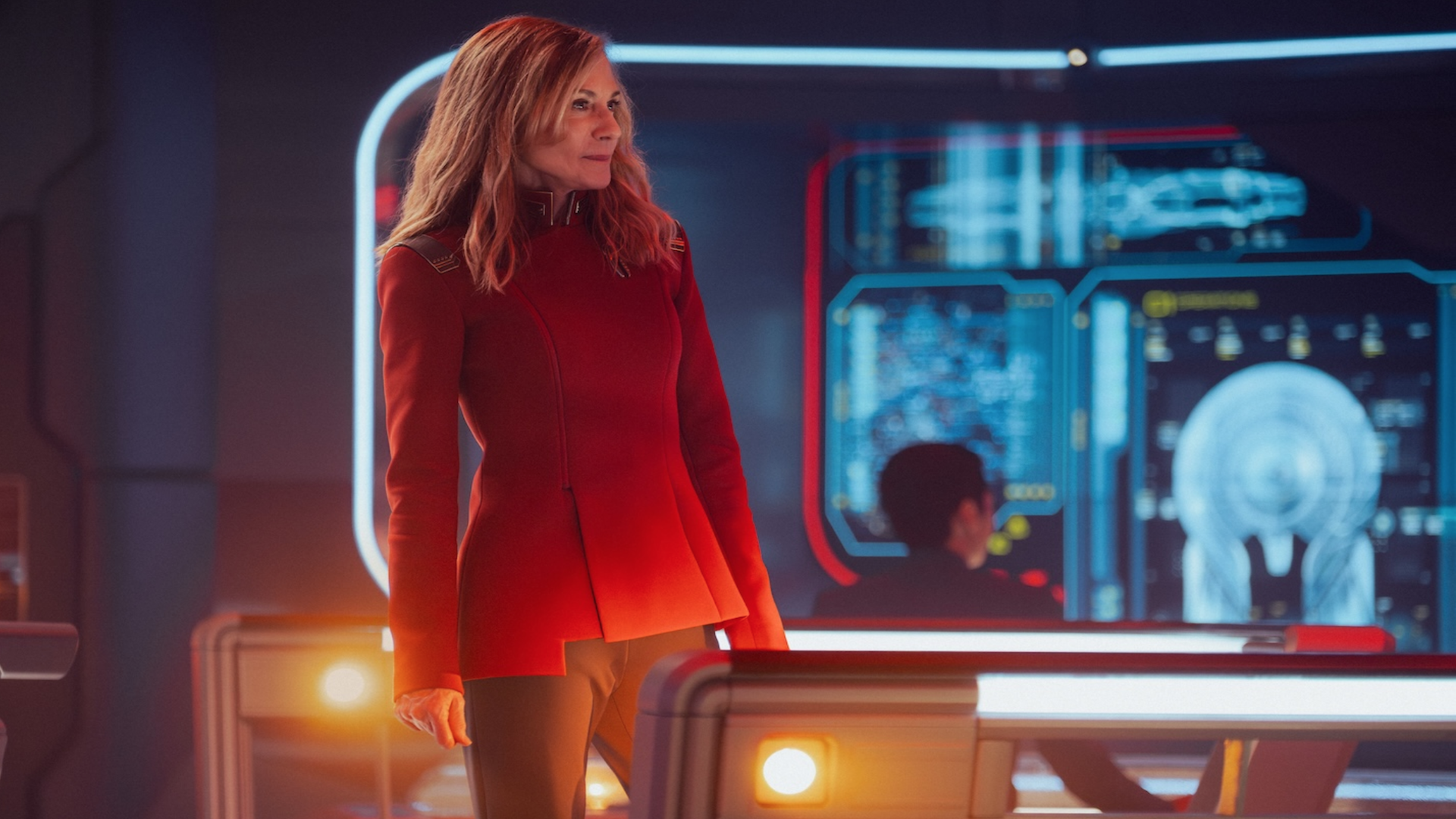 a female starship captain stands on the bridge