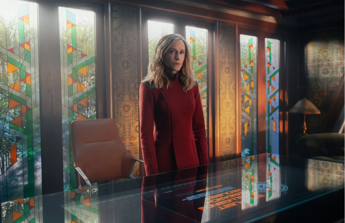 a woman in a red uniform inside a fancy starship