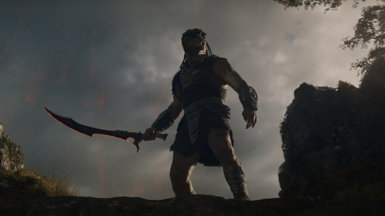 a silhouette of a humanoid alien in front of a foggy alien landscape