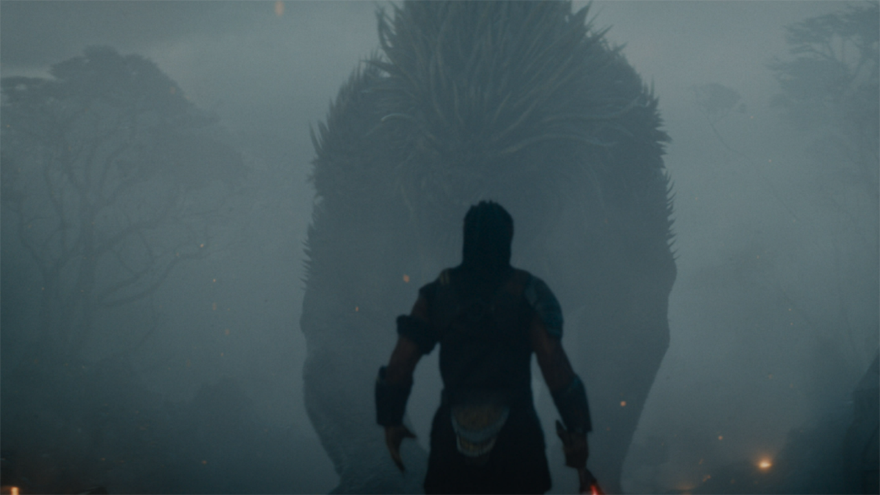 a silhouette of a humanoid alien in front of a foggy alien landscape