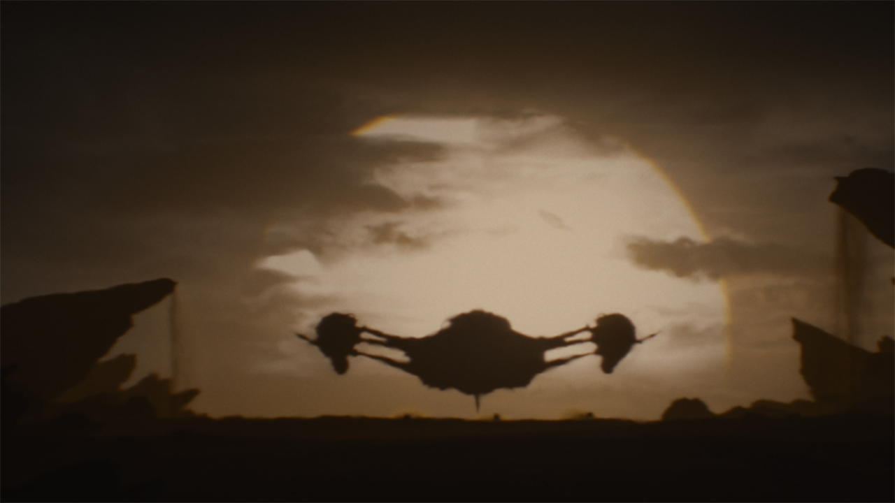 a silhouette of a humanoid alien in front of a foggy alien landscape