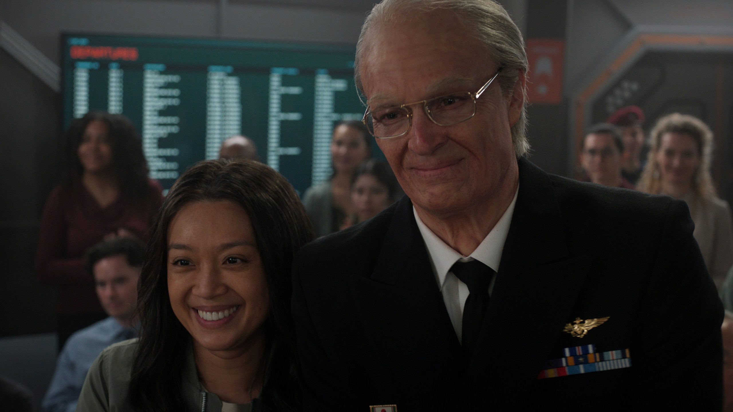 An older man in a suit and a smiling woman