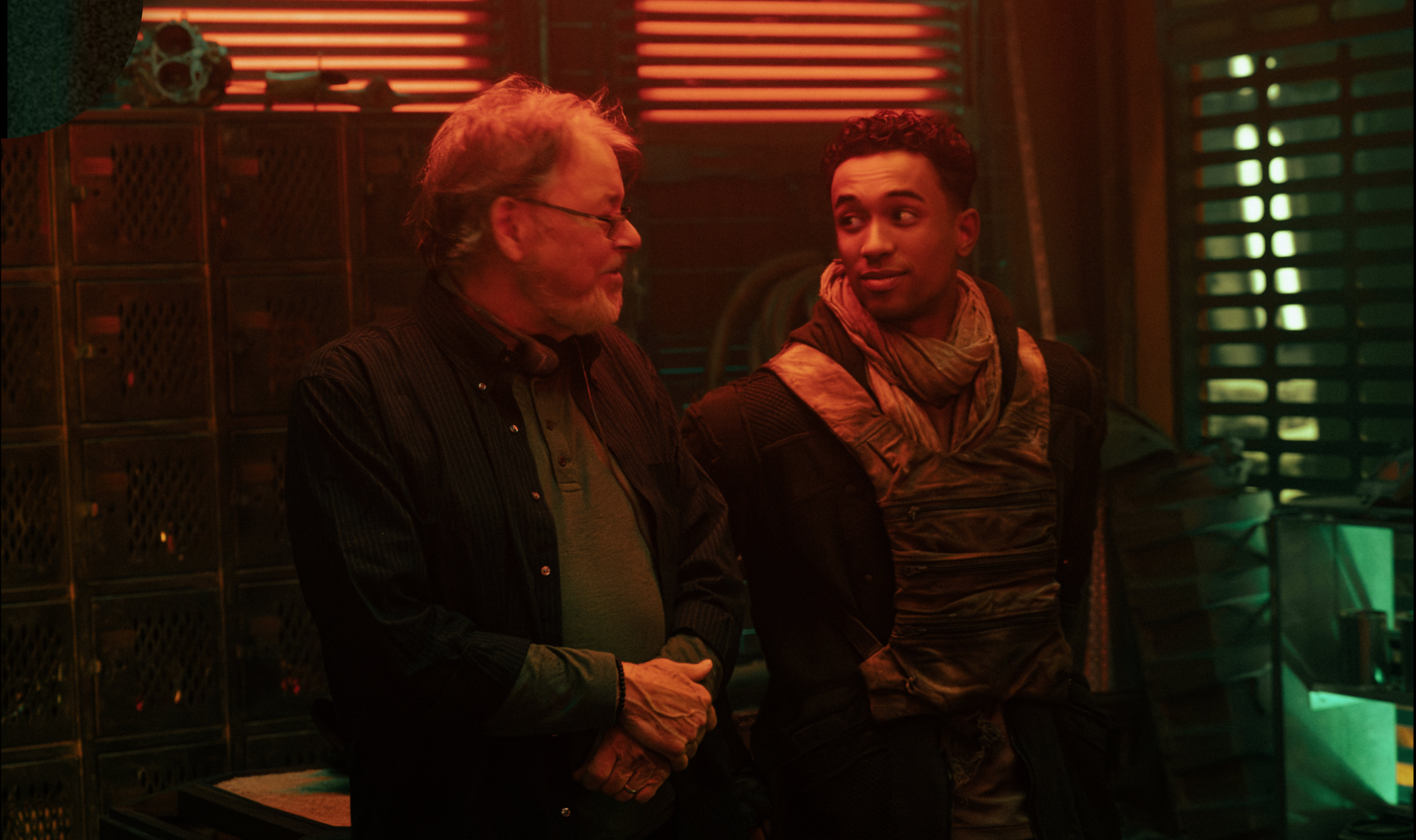 a director on a sci-fi set speaking with a young actor