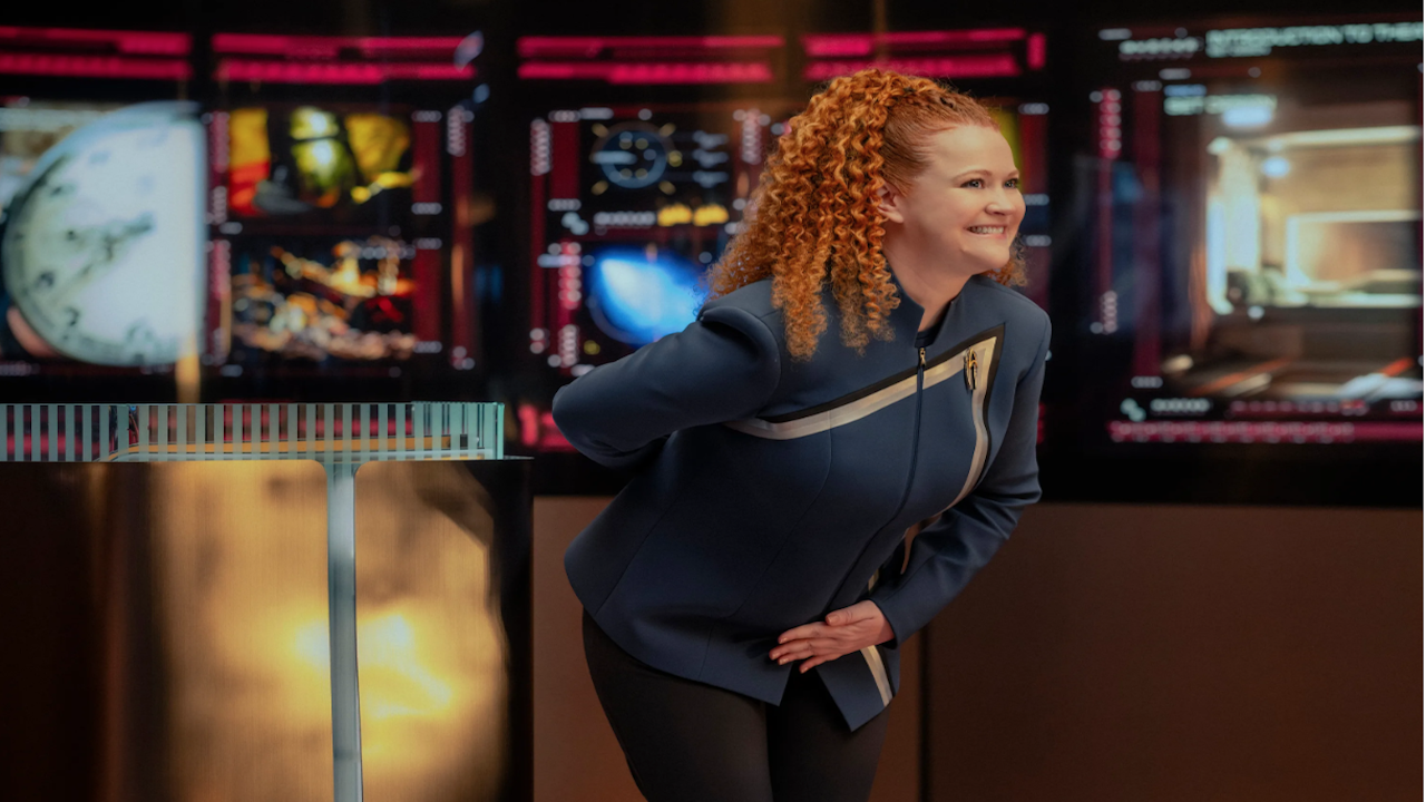 a woman with red hair bows wearing a blue sci-fi uniform