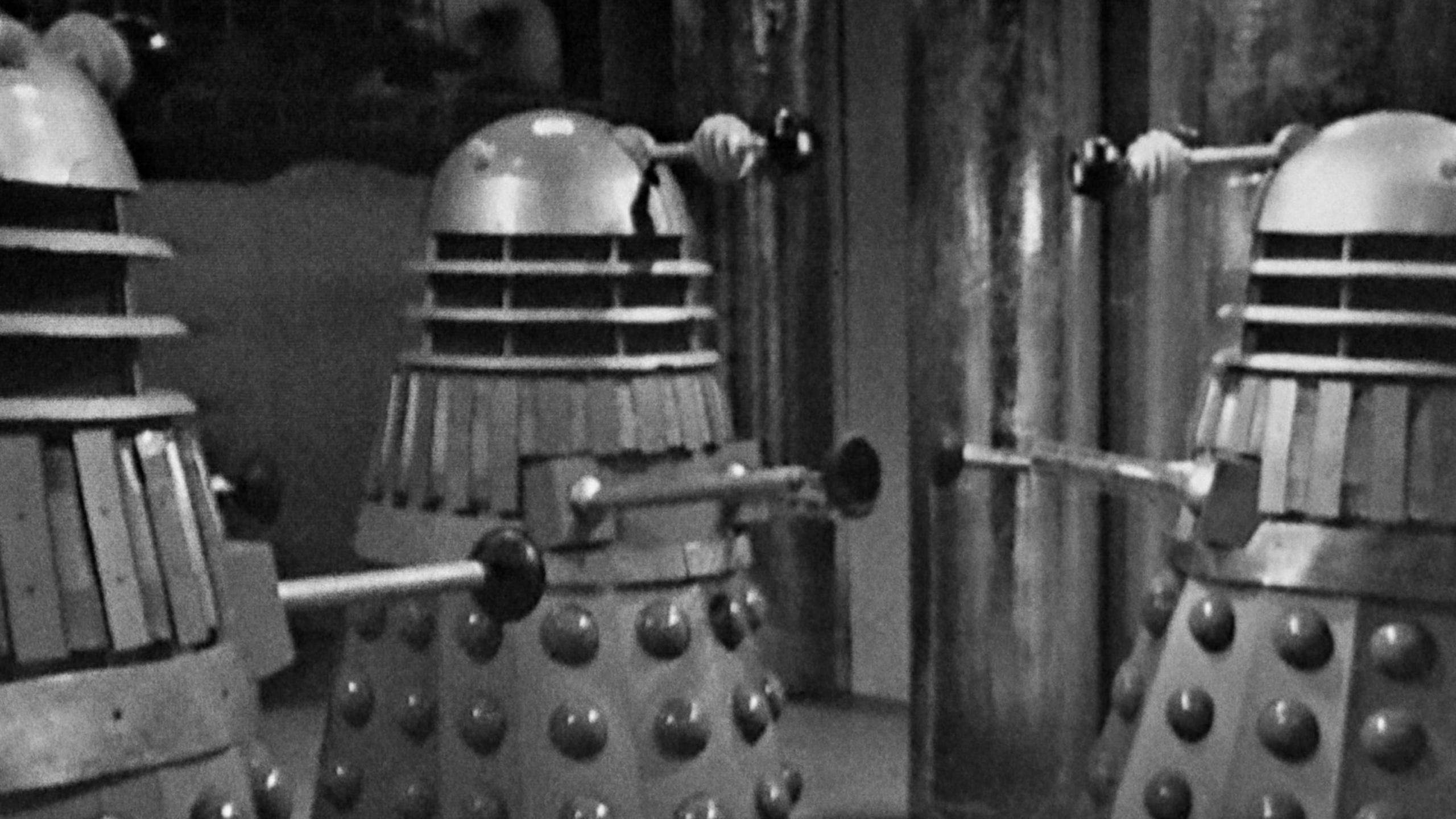 Three Daleks, in black and white.