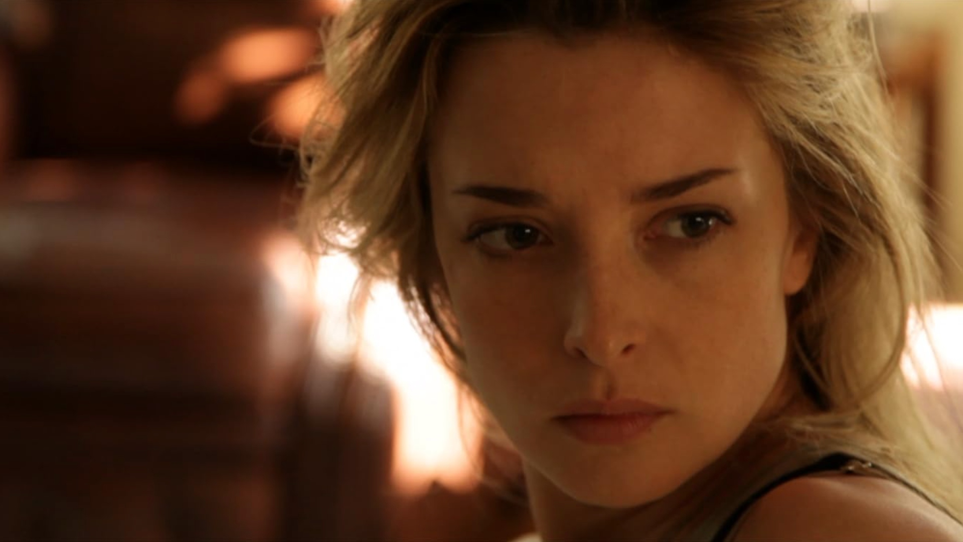 A blond woman looking intensely at something off screen behind the camera. Scene from the 2013 American science fiction psychological thriller 